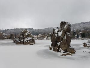 um grupo de grandes rochas em um campo coberto de neve em Chalet au bord du lac em Aydat