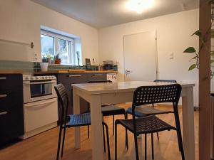 a kitchen with a table and chairs in it at Chalet au bord du lac in Aydat