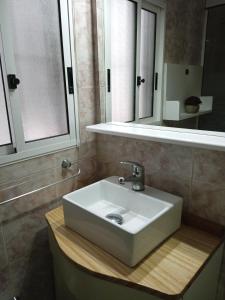 Un baño con un lavabo blanco y un espejo. en Ronald, en Piriápolis