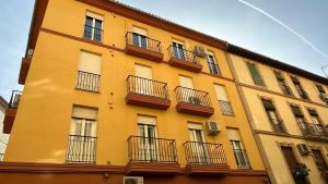 a yellow building with balconies on the side of it at Ático en el centro de Granada in Granada
