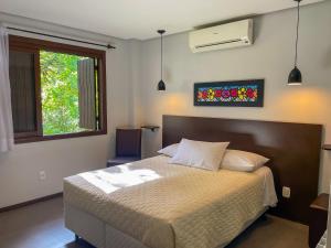 Un dormitorio con una cama grande y una ventana en Pousada Das Araucarias, en Canela