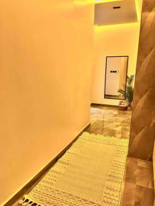 a hallway with a rug on the floor and a wall at استديو فاخر حي حطين بجوار البوليفارد in Riyadh