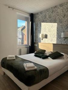 um quarto com uma cama grande e toalhas em Hotel De La Mer em Saint Malo
