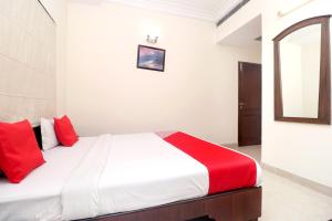 阿姆利則的住宿－寺廟景酒店，一间卧室配有红色枕头的床
