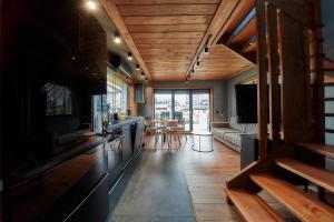 a kitchen and living room with wooden ceilings at Domki 1010 m in Ząb