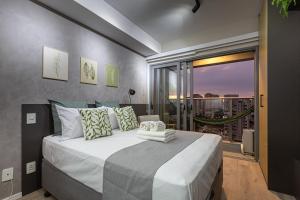 a bedroom with a large bed with a view of a city at Easy Star - Studio Incrível em Moema - ET04H in São Paulo