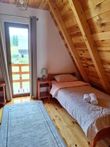 a bedroom with a bed and a large window at House Bojana in Žabljak