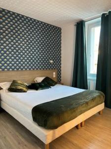a bedroom with a large bed with a large headboard at Hotel De La Mer in Saint Malo