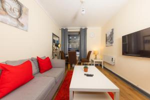 sala de estar con sofá gris y almohadas rojas en Cozy Old Town 4 Bedrm Apartment en Edimburgo