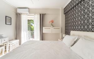 a white bedroom with a large bed and a window at Seaside Beauty 5 min Vouliagmeni Beach in Athens
