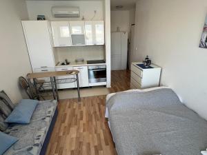 a small room with a bed and a kitchen at Sea view & pool studio by Pag tours in Pag