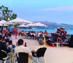 um grupo de pessoas sentadas em mesas numa praia em Chalet con piscina y diversión Ría de Vigo em Vilaboa