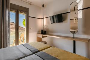 1 dormitorio con cama, espejo y ventana en APARKTION The Grand Maistro, en Lixouri