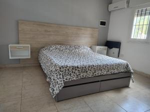 a bedroom with a bed with a black and white comforter at CASA WRT in Villa Carlos Paz