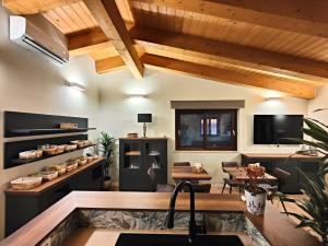 a kitchen and living room with wooden ceilings at B&B Casa MariLù in Fuscaldo