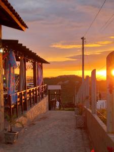 um pôr do sol a partir da varanda de uma casa em Entre Serras Gastropub e Chalés em Monte das Gameleiras