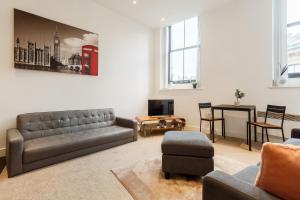 a living room with a couch and a table at Smart Living Apartments - One Beds in Bradford