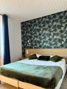 a bedroom with a large bed with a wall at Hotel De La Mer in Saint Malo