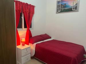1 dormitorio con cama roja y ventana en Dream of angels home en Santa Ana