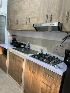 a kitchen with a stove top and wooden cabinets at Dream of angels home in Santa Ana