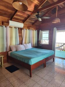 ein Schlafzimmer mit einem Bett in einem Zimmer mit Holzdecken in der Unterkunft Coco's Beachfront Cabanas in Seine Bight Village