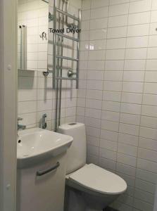 biała łazienka z toaletą i umywalką w obiekcie Helsinki Apartment near downtown w Helsinkach