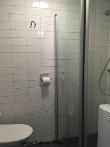 y baño con ducha y rollo de papel higiénico. en Helsinki Apartment near downtown en Helsinki