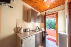 a small kitchen with a sink and a window at Mimosa Apartments with Pool in Paleokastritsa