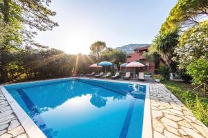 a swimming pool with chairs and umbrellas in a yard at Mimosa Apartments with Pool in Paleokastritsa