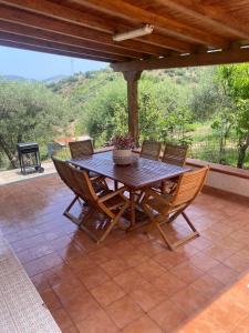 a wooden table and chairs on a patio at Cicero’s - Intero alloggio in Castelbuono