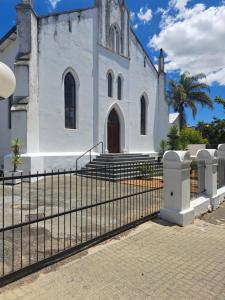 una iglesia con una valla delante de ella en The Stetson en Paarl