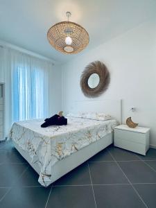 バデージにあるAppartement Baia delle Mimose i6のベッドルーム1室(ベッド1台、壁掛け鏡付)