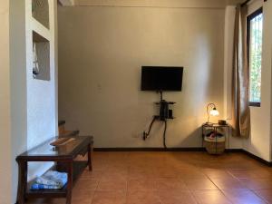 sala de estar con TV de pantalla plana en la pared en Casa Sueno Colibri en Tamarindo