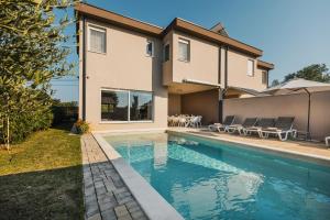 a house with a swimming pool in front of a house at VILLA JADRANKA in Krnica