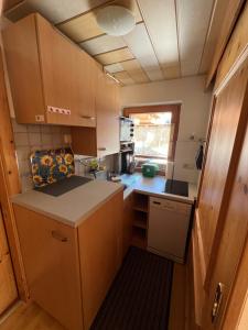 eine kleine Küche mit Holzschränken und einem Waschbecken in der Unterkunft Ferienwohnungen Unterfeld in Alpbach
