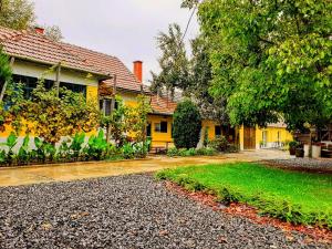 una casa amarilla con una entrada delante de ella en Kis-Tisza Apartmanházak Tokaj- hegyalja en Tiszaladány