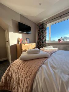 ein Schlafzimmer mit einem Bett mit zwei Handtüchern darauf in der Unterkunft Brian’s Escape in Great Driffield