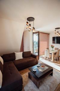 sala de estar con sofá marrón y mesa en Apartman Petar 26, en Divčibare