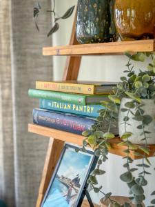 uma pilha de livros numa prateleira com uma fotografia em Little Curlew, Ynyslas, Borth em Borth