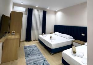 um quarto de hotel com duas camas e uma casa de banho em Hotel Krial em Berat