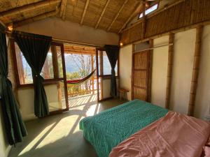 ein Schlafzimmer mit einem Bett in einem Zimmer mit Fenstern in der Unterkunft Cabañas Ecoturismo Evy in Macanal