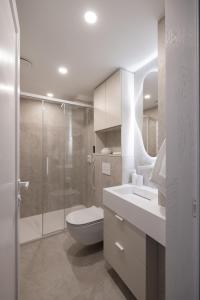 bagno bianco con servizi igienici e doccia di Boutique Penthouse a Vilnius