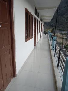 an empty hallway with blue chairs and a balcony at Utterkashi Prithvi yatra hotels in Uttarkāshi