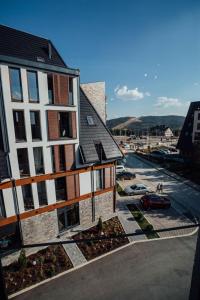 ein Gebäude mit einem Parkplatz neben einer Straße in der Unterkunft Apartman Petar 26 in Divčibare