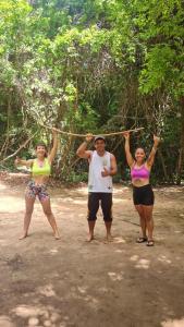 un grupo de tres personas sosteniendo una cuerda en Hostel Terra Viva en Pipa