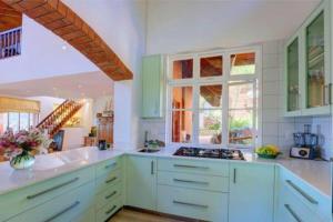 a large kitchen with white counters and a window at Wilderness deckhouse. views!/sun/sea/river/kayaks in Wilderness