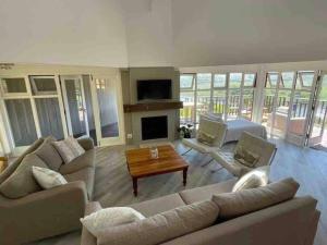 a large living room with couches and a fireplace at Wilderness deckhouse. views!/sun/sea/river/kayaks in Wilderness