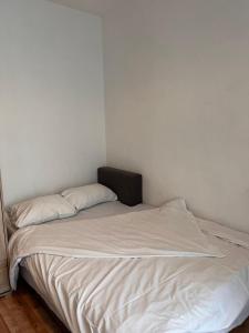 łóżko w pokoju z białą pościelą i poduszkami w obiekcie Bright Rooms w Krakowie