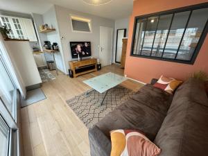 un soggiorno con un divano e una TV di Chez Tonton, Studio cabine au calme avec parking a Le Touquet-Paris-Plage