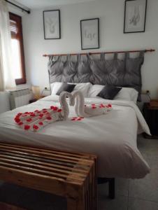 Una cama con dos cisnes y rosas rojas. en Casa Vitoria, en Monroyo